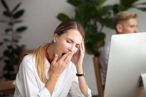 Woman yawning at her desk