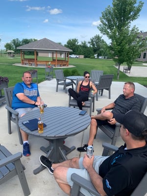 team drinking beers while sitting around table