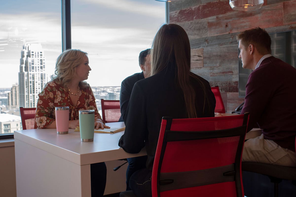 4 Granite Logistics employees sitting around a table talking