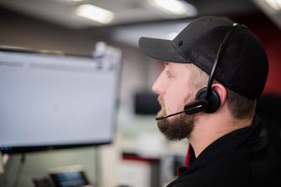 man in headset looking at computer