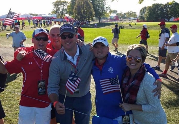 employees holding flags and smiling outdoors