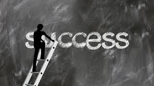 chalkboard image of the word success written by figure on ladder